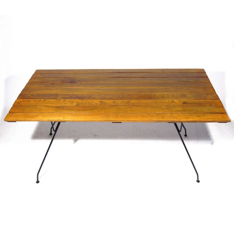 Arthur Umanoff for Raymor dining table. Deep amber wood slats  supported by black welded iron framework. Original feet intact. Great character. Seats six. We do have six matching chairs, four shown in photos.

Restored condition, both metal and