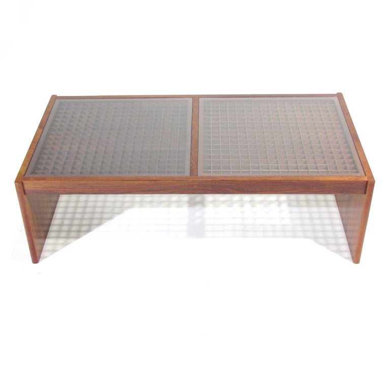 Handsome Danish rosewood coffee table crafted by Komfort. 16 x 16 square grid panels on each half beneath glass. Quite substantial in scale.
