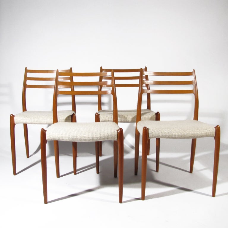Four sculptural Danish teak Moller Model 78 dining chairs upholstered in oatmeal woven wool. Very comfortable with gentle angled curved backs.

Perfect teak and upholstery.