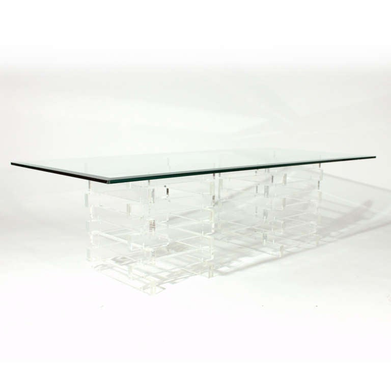 Nice vintage lucite cocktail/coffee table. Two columns of stacking rectangular lucite blocks or panels form the base supporting a thick beveled glass top. You can position the two bases so that they are either parallel with the table top or at a