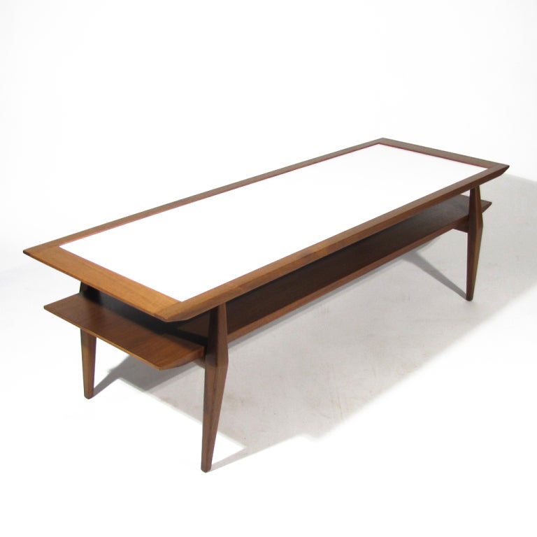Exceptional Bertha Schaefer cocktail table crafted in Italian walnut with white laminate top. Crisp lines with M. Singer & Sons label affixed to underside. Rare and in excellent condition.
