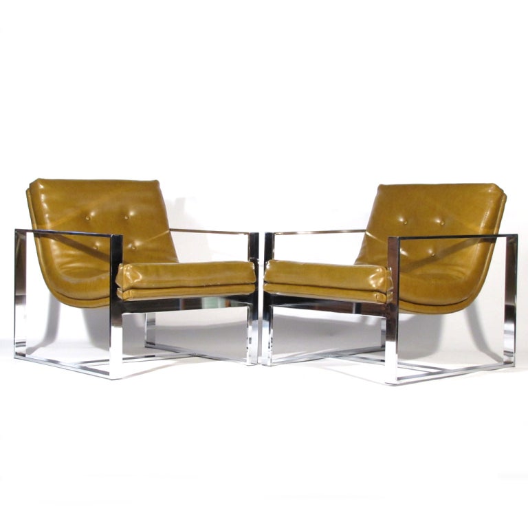 Brilliant pair Milo Baughman flat bar chrome lounge chairs upholstered in mocha leatherette. Material in fine condition, but we can assist with new upholstery. Heavy chrome with extremely comfortable scoop form seats.

Shiny scratch free chrome.