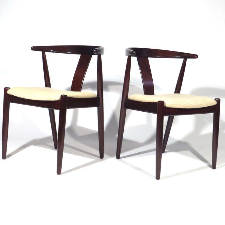 Pair sculptural Danish teak accent chairs. Gorgeous color. Very comfortable with deep crescent backs. Nice joinery in top middle 

Excellent overall condition. Cream upholstery very good, but new upholstery recommended.