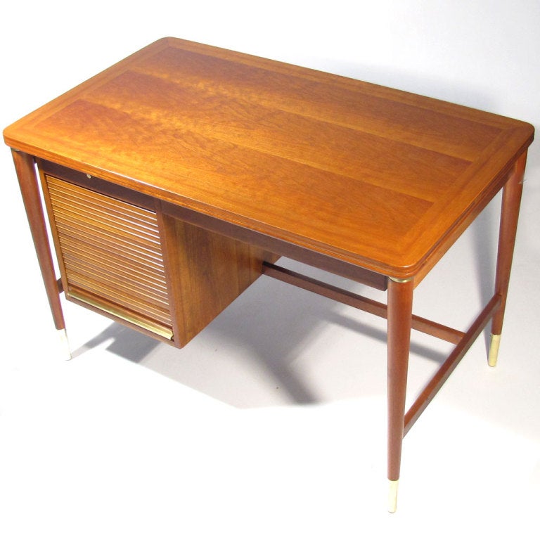 John Widdicomb desk with sizable work surface. Beautiful cherry wood top, with pull out shelf, tapered legs, and tambour door revealing three drawers, all accented by polished solid brass rings, pulls, and feet. Finished on all four sides. Widdicomb