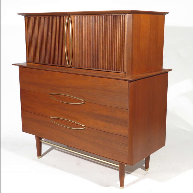 Streamlined Hobey Helen for Baker walnut chest of drawers with three central drawers, flanked by grooved doors, each revealing three interior drawers. Brass stretchers, pulls, and sabots. Excellent restored condition.