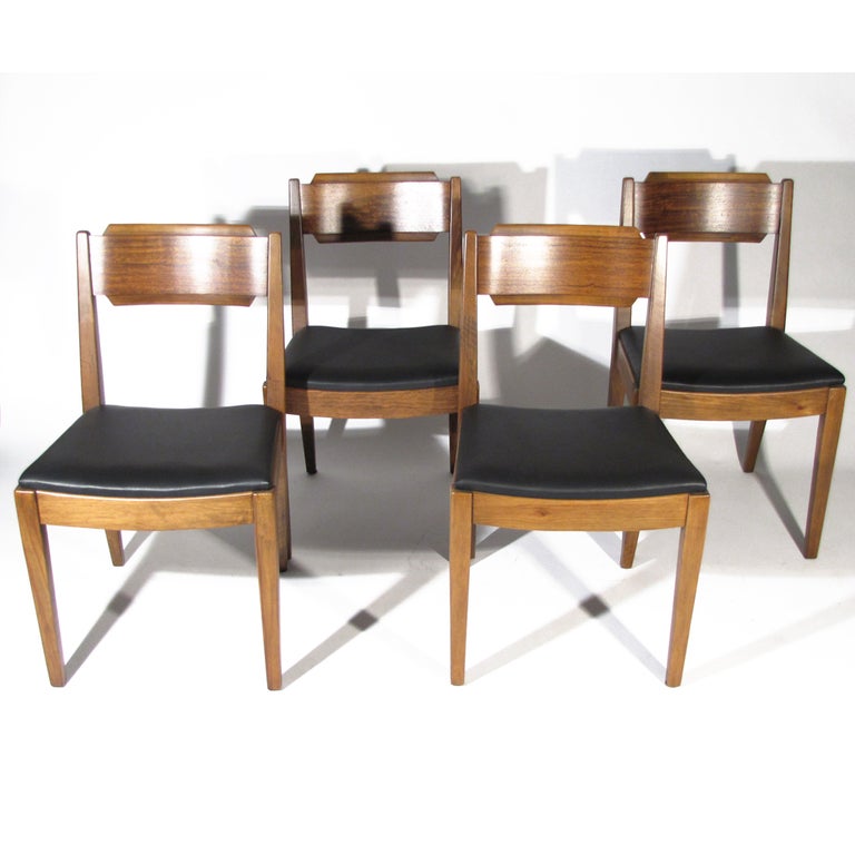 Handsome set of four Milo Baughman dining chairs. Walnut frames featuring beautiful primavera curved backs with ribbon figuring. Newly upholstered black leather seats. Milo Baughman for Drexel Perspective line. 

Overall excellent restored