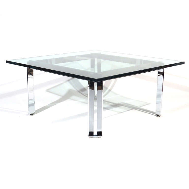 Crisp coffee table having a heavy solid chrome plated steel parallel bar base. New glass top.