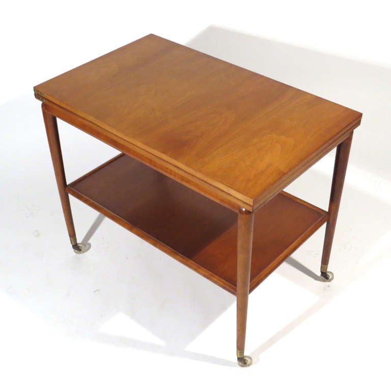 Rare T.H. Robsjohn-Gibbings flip top table or server with lower shelf. Top flips open with and glides with ease to double top surface, and locks into place. Brass hinges and sabots. Dimension closed 36