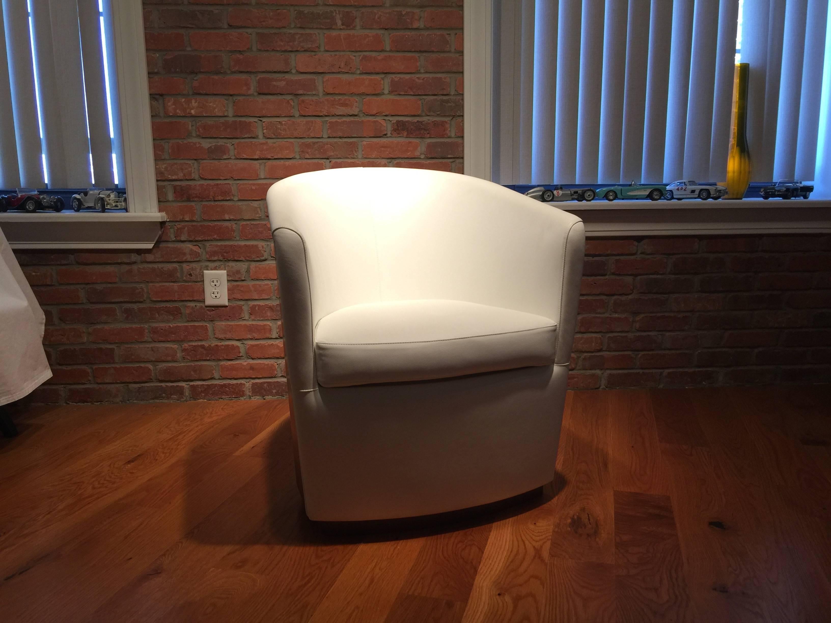 A modern designer Italian armchair, made of a walnut finished curved wood back and base with white leather upholstery. From display, very good condition, on sale. Retail price was 4,000$. The armchair swing left and right and returns to its original