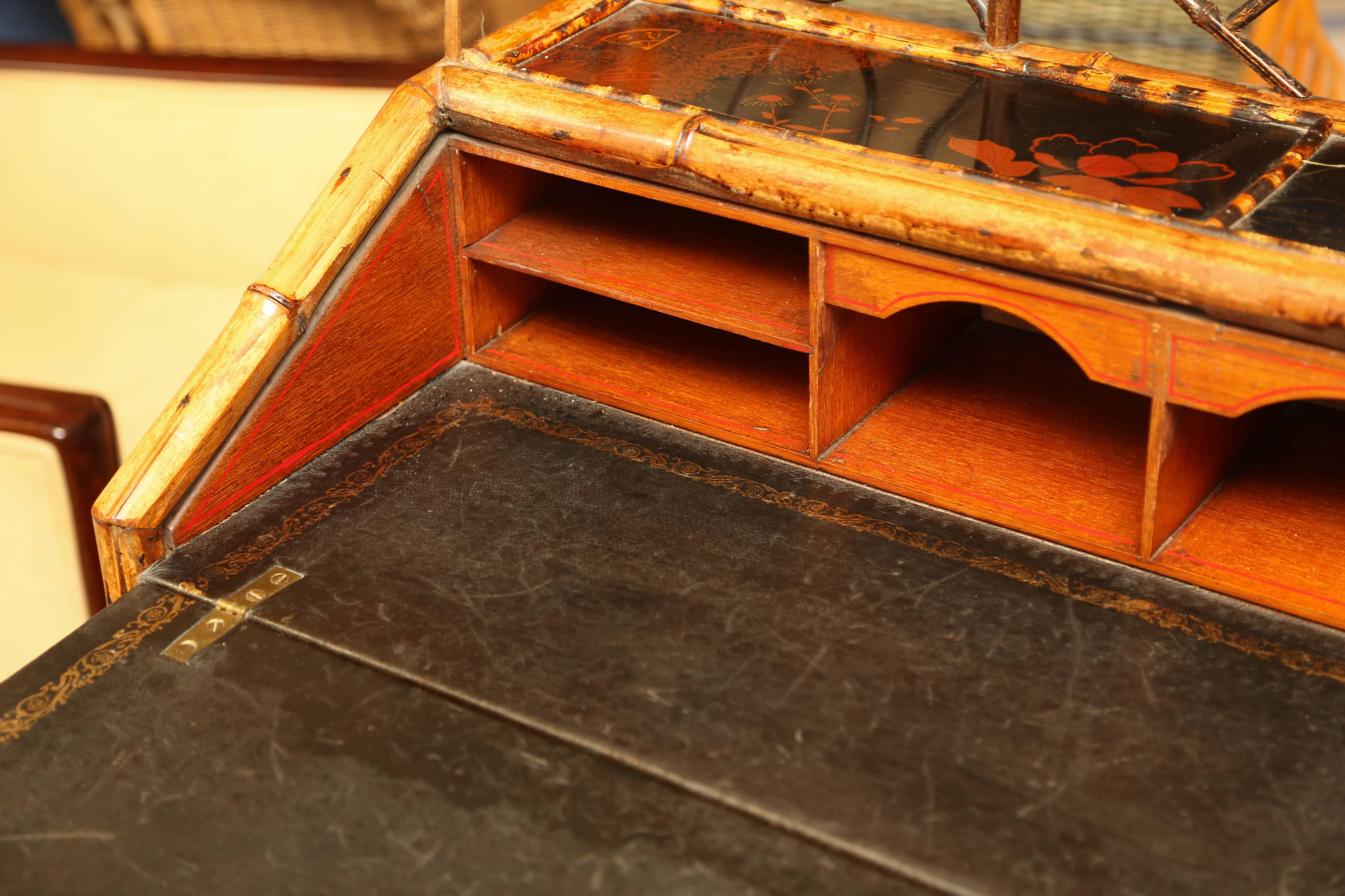 19th century bamboo ladies knee-hole desk. Original lacquered decoration, slant-lid enclosing compartmented interior, with exterior drawers paneled doors. Measures: 45-1/2