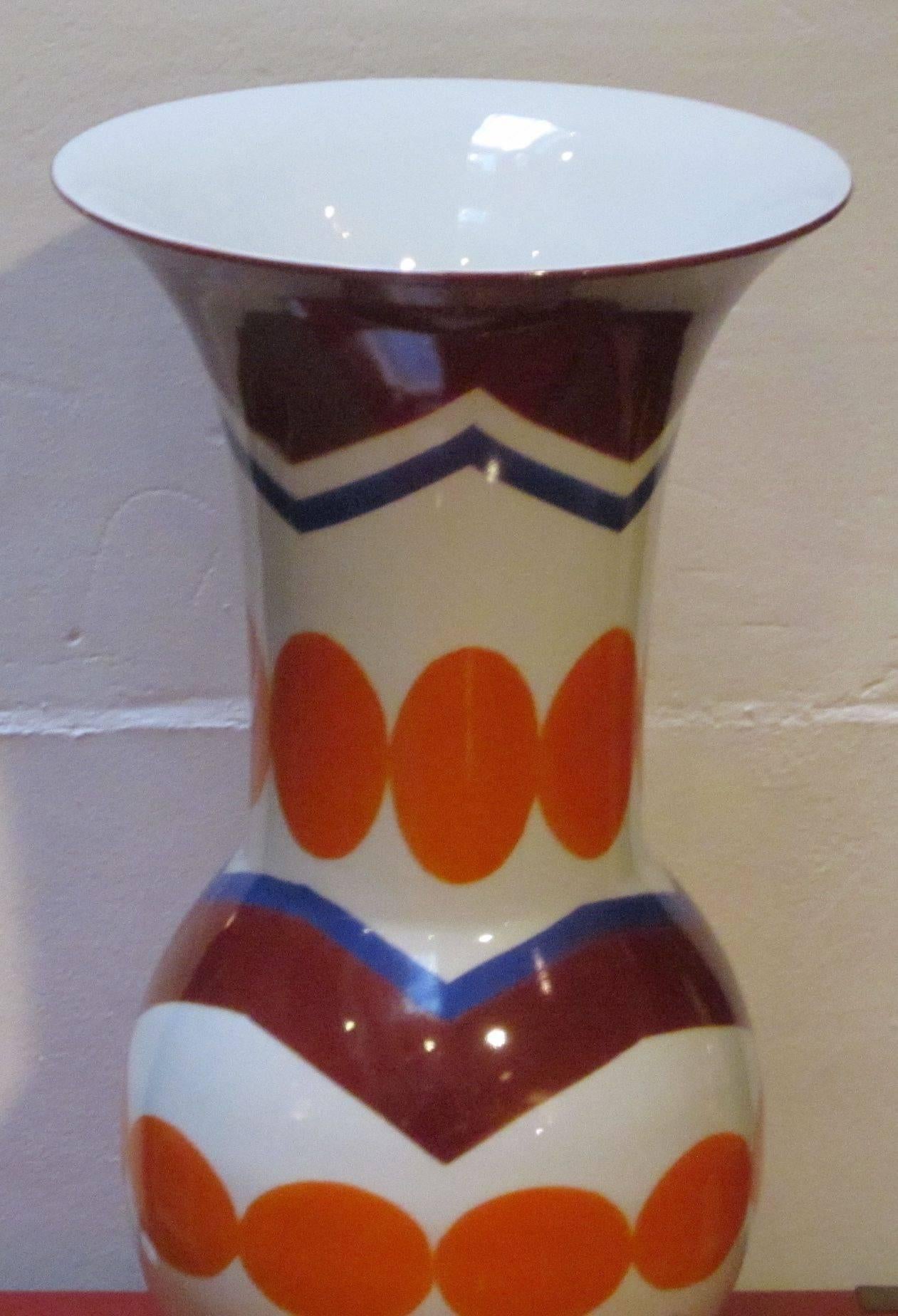Contemporary Chinese brightly colored porcelain tulip vase.
Colors are white ground, orange circles and burgundy zig zag design.
 