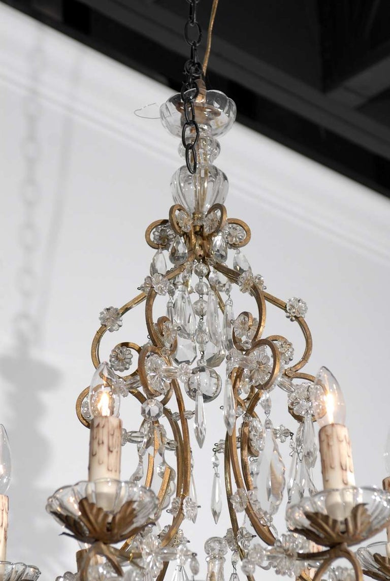 An Italian Rococo style six-light crystal chandelier form the late 19th century, with gilt armature. This exquisite Italian crystal chandelier features a scrolling gilt armature, delicately supporting an abundance of crystals, from faceted ones to