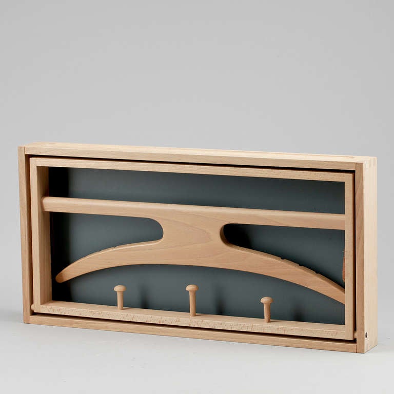 A compact folding wall mount valet with shirt hanger, pants crossbar, and three pins for ties and accessories. By Adam Hoff and Poul Ostergaard. Danish, circa 1960.
In very good condition.
Oak and leather belts.
L: 55.

Several available !!