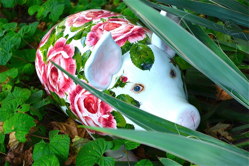 Decorated in pink cabbage roses surrounded by vibrant green leaves on a crisp white background. The pig has bright blue eyes with detailed eyelashes. This piece rests on three legs; the creators omitted the fourth leg. Made in Devon, after Weymss