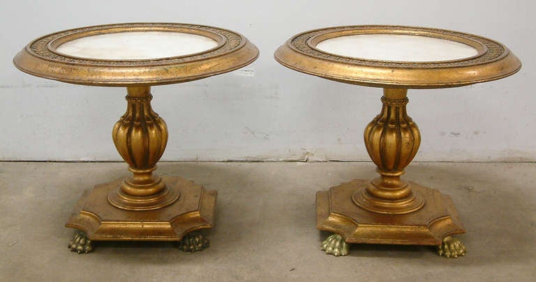 A pair of classical occasional tables with a nod to surrealism in the Hollywood Regency style with cast bronze paw feet and abalone shell inset tops with a clear acetate cover.  Each gilt table is impressed under the top with the numbers 2763.  A
