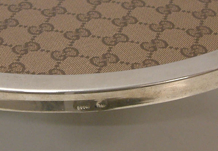 A very chic and rare round serving tray by the fashion house of Gucci. The tray is impressed Gucci Italy on the side of the silverplate frame and is mounted on a black plexiglass insert.