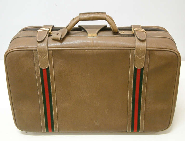 Travel in high style with this superbly crafted Gucci suitcase.  The interior is fabric lined and includes a vinyl shoe / accessories bag and the brass Gucci nameplate.The exterior includes the impressed signature to the brass hardware and four