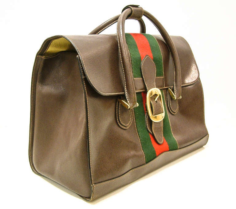 A stunning and rare Gucci travel satchel style bag in smooth brown leather with the classic Gucci red and green striped fabric.  The interior is fabric lined and the brass zipper is stamped Gucci and the leather bag is embossed MADE IN ITALY by