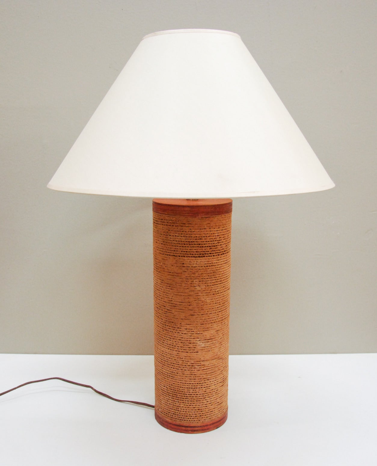 A cylindrical cardboard and plywood table lamp that is often incorrectly attributed to Frank Gehry and the Easy Edges line.  This Gregory Van Pelt for Raymor lamp has a beautiful golden patina to the plywood and is in excellent