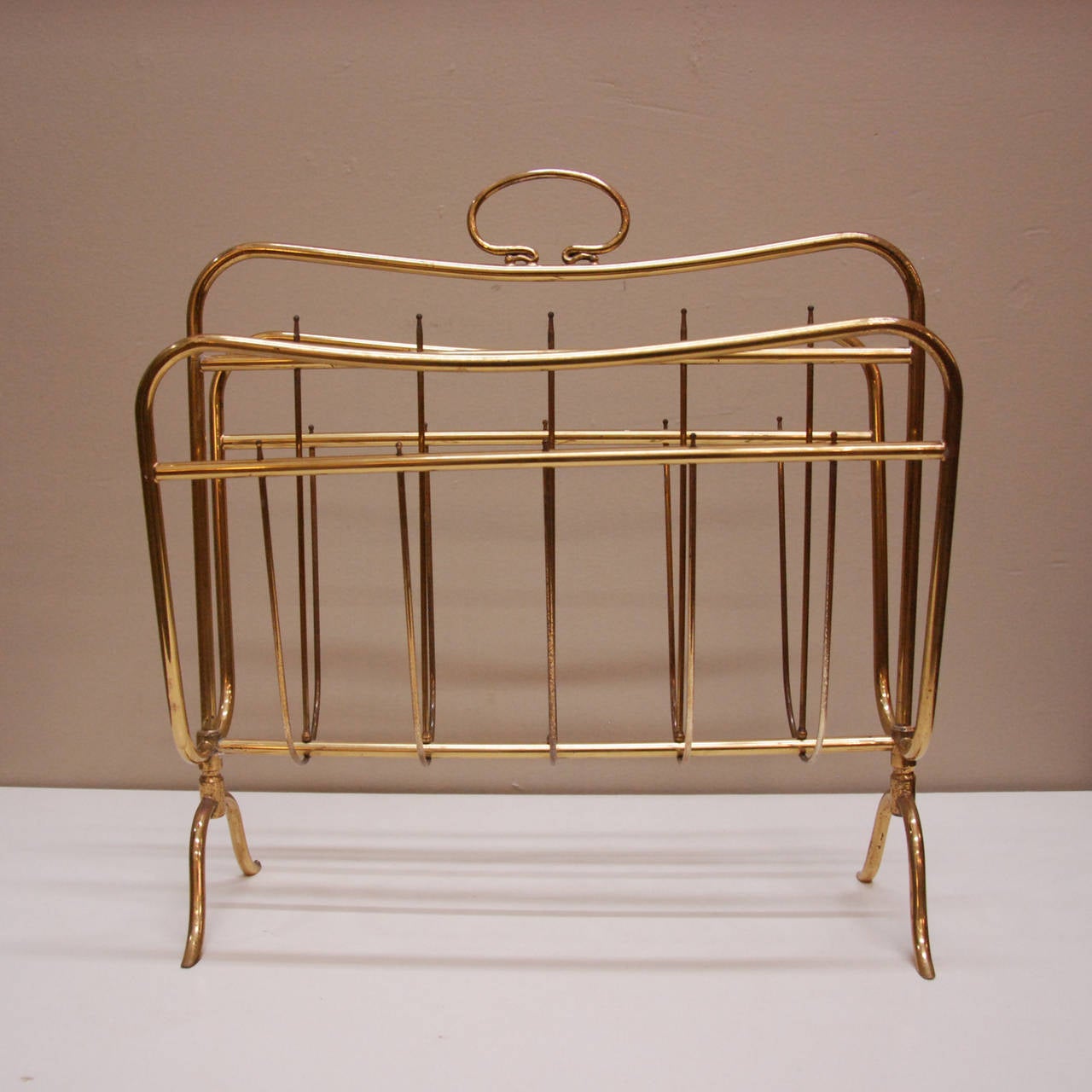 A very stylish biomorphic brass magazine holder attributed to the manufacturer Maffeis that is so representative of its era.