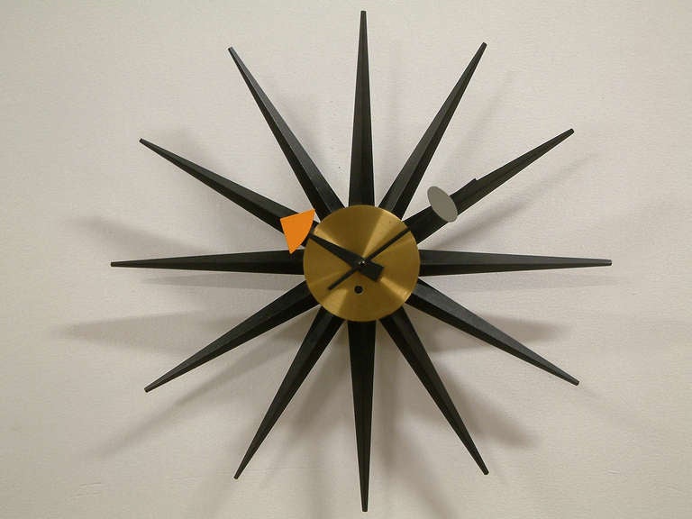 A rare and early wind-up model of the famous spike clock manufactured by the Howard Miller Clock Company made of lacquered wood, enameled metal and brass.  The impressed manufacturer's mark is on the reverse.  Small minor tarnish spot on brass.