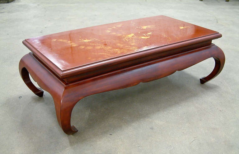 A beautiful cinnabar lacquered coffee table in the Asian style with an updated stylized base of mortise and tenon construction.  The lacquered top depicts goldfish swimming through seaweed and the base is signed and dated on a brass nameplate.