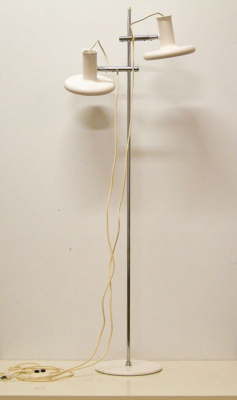 A high style designer floor lamp probably designed by Johannes Hammerborg for Fog & Mørup with two pivotal shades and Dual cords terminating into a foot switch. The lamp is polychromed white with a tubular chrome shaft and stainless steel hardware.
