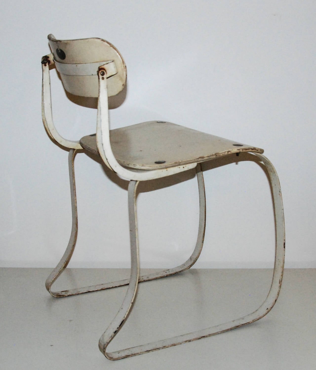 A fine and early example of the Health Chair designed for industrial machine operators.  The laminated plywood on the seat and back were later replaced with stamped metal in the 1940s. The back pivots and has an applied decal with patent no.
