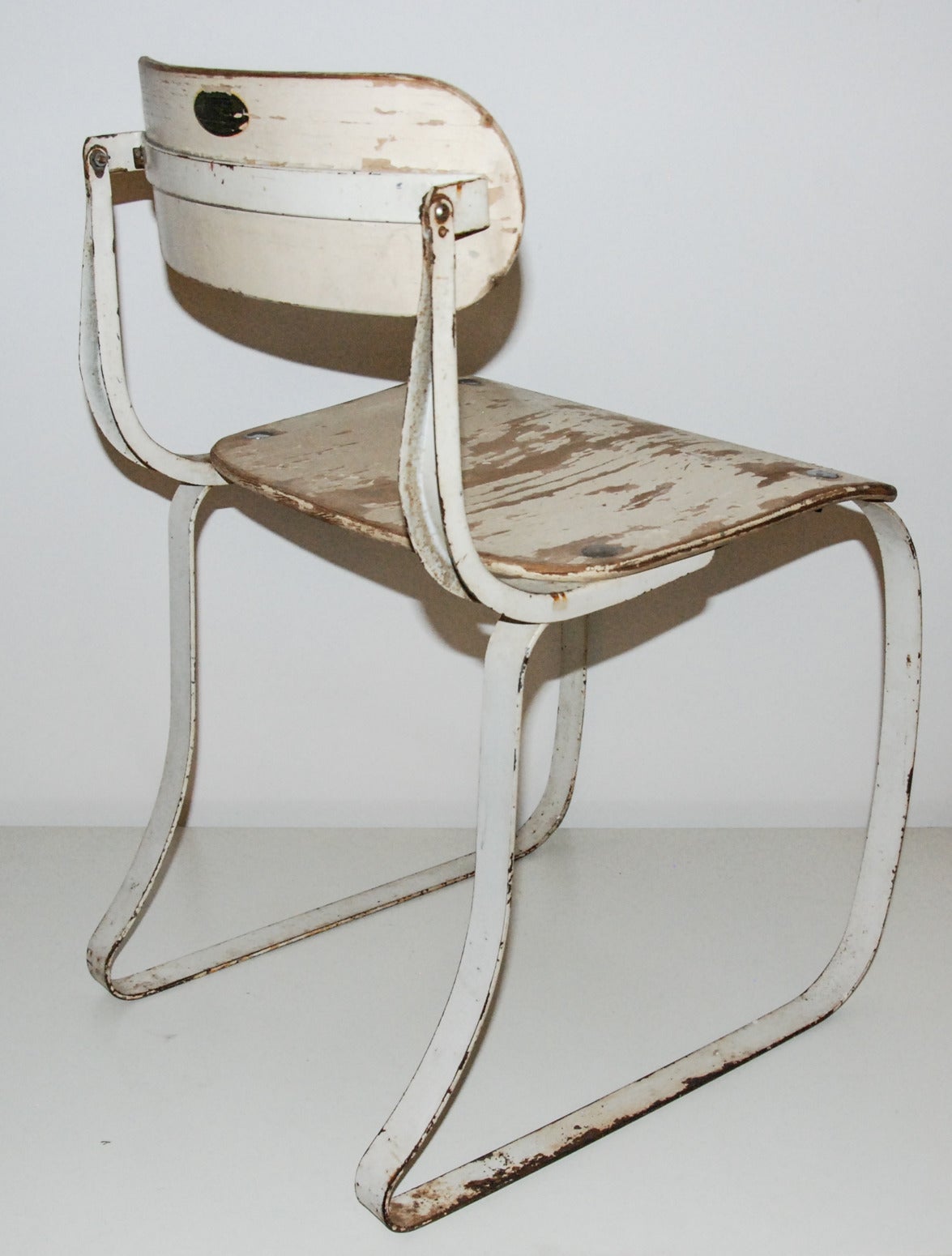 A fine and early example of the Health Chair designed for industrial machine operators. The laminated plywood on the seat and back were later replaced with stamped metal in the 1940s. The back pivots and has an applied decal with patent no.