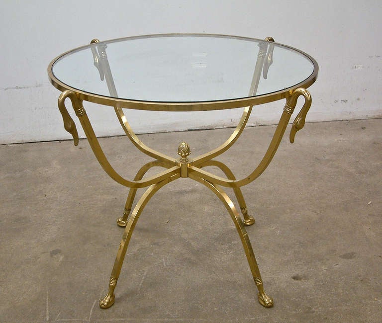 A fine brass and glass table meticulously crafted in the style of Maison Jansen.  Impressed 