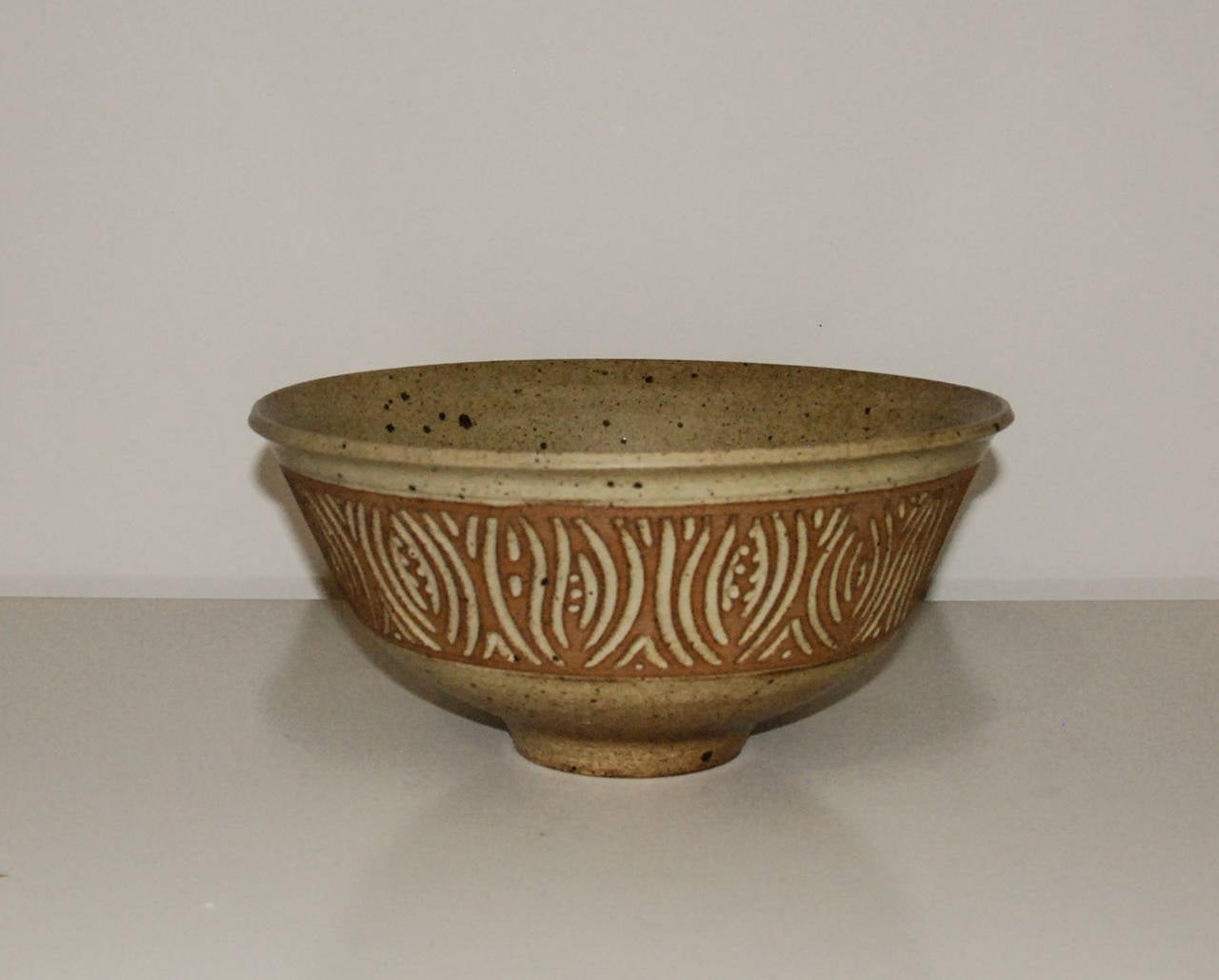 A fine and large sgraffito stoneware bowl by master potter Peter Lane with a matte glaze.  Lane has exhibited his large scale architectural room dividers and lamps at the Pavilion of Art and Design in New York City and is represented in the United