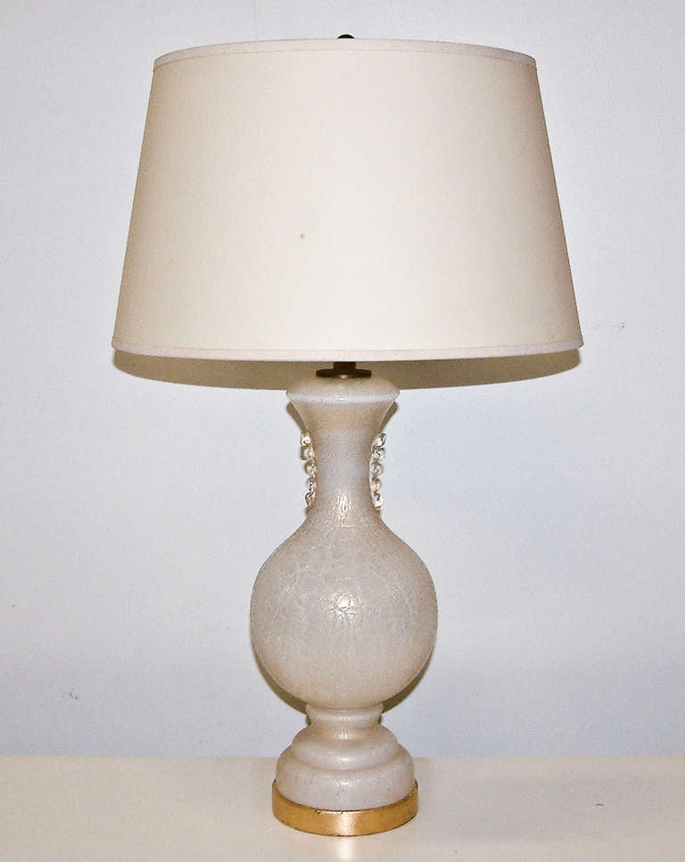 A very sophisticated Murano white glass lamp with decorative gold inclusions in the manner of Tommaso Buzzi.  The glass body is mounted on a gilt wood base.

Base:  4.88