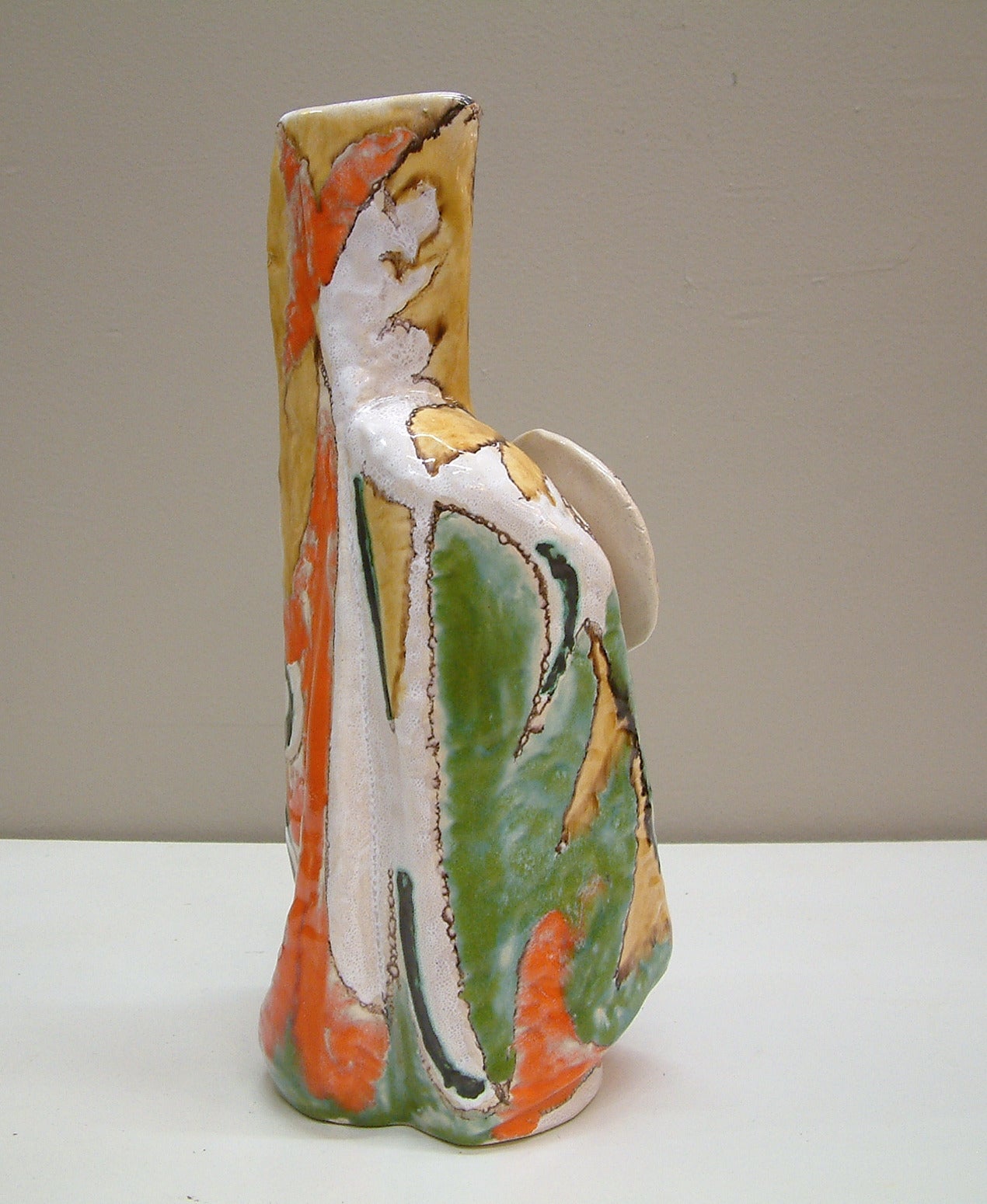 A hi-glaze figurative vase by master potter Elio Schiavon who studied at the Scuola d'Arte Ceramica di Nove and later opened a furnace in Padova, Italy in 1954. Schiavon was born in Padova in 1925 and participated in and won awards in many