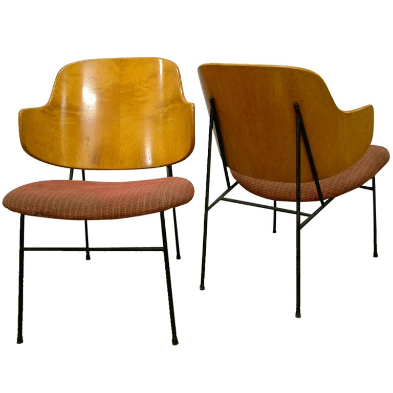 A nice pair of Ib Kofod-Larsen lounge chairs with a beechwood moulded plywood back, enameled steel frame and original cotton fabric upholstery. The chairs are branded 