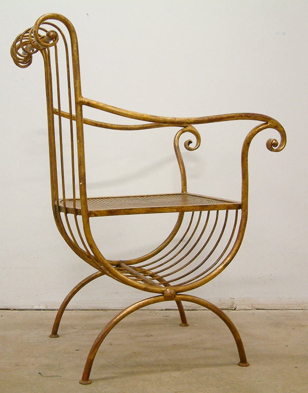 An elegant Italian gilt metal chair with scroll arms in the neoclassical style.