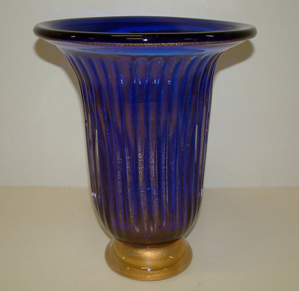 An impressive Murano vase of deep blue glass with gold foil  inclusions reminiscent of the work of Seguso and Barovier and Toso.  The ribbed body is decorated with gold leaf and the clear glass base is enhanced by submerged gold particles.