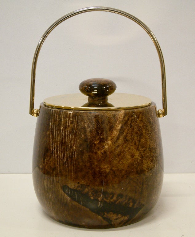 A brown parchment and brass lidded icebucket with plastic liner by Aldo Tura.
