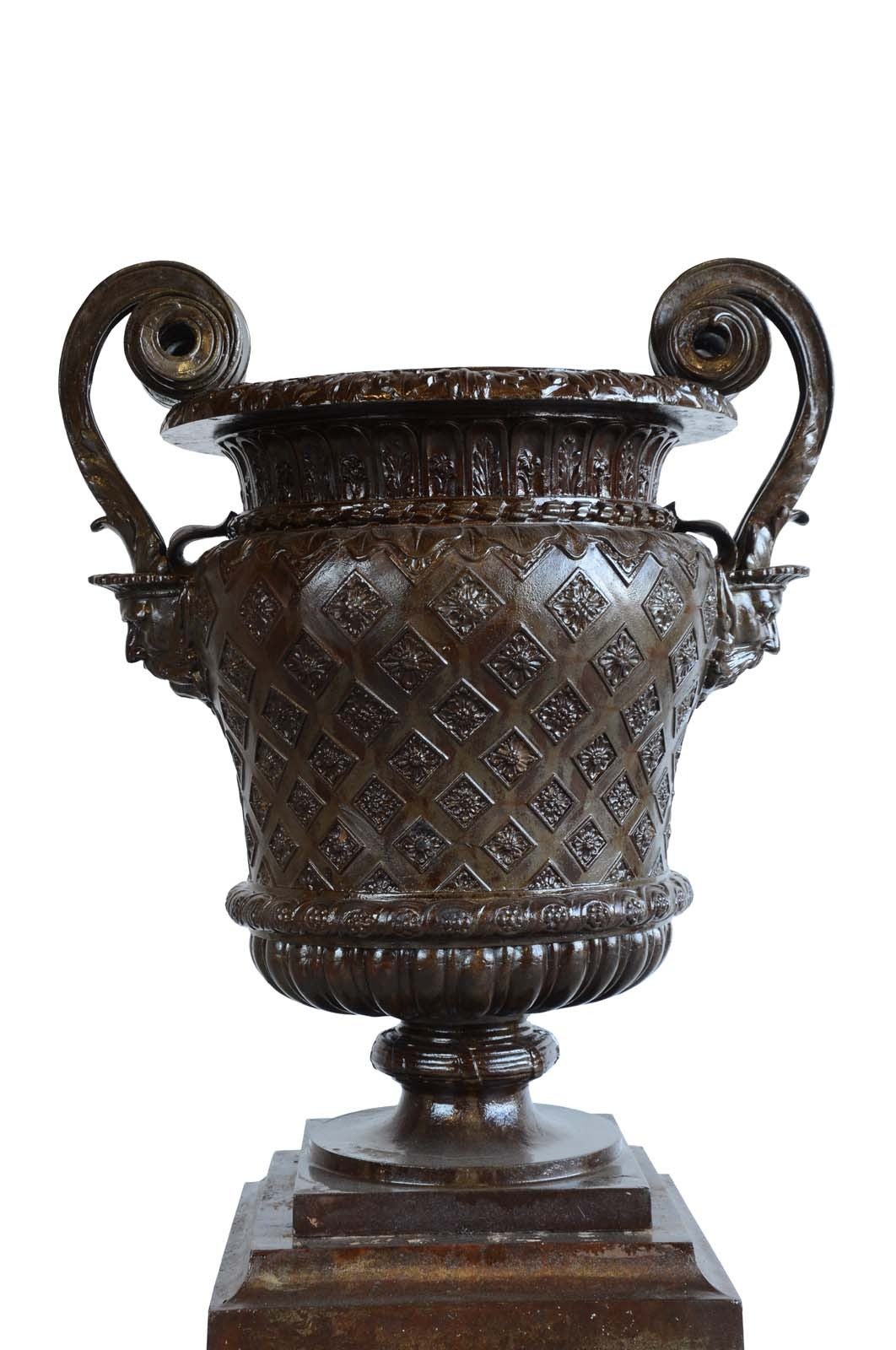 French Louis XIV style cast iron vase and its pedestal.
Dimensions:
Pedestal: 15 x 16 x 16 in.;
Vase: 32 x 28 x 20 in. (Base 11 x 11 in.).
 