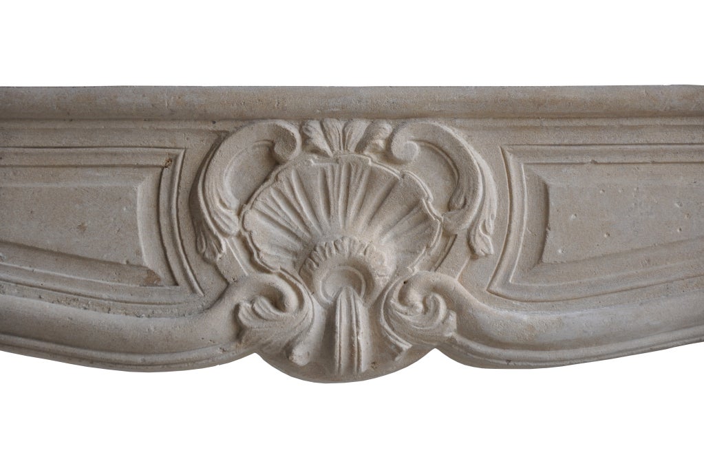 A French Louis XV period limestone fireplace dated 18th century. Hearth opening : 36 x 45 in.