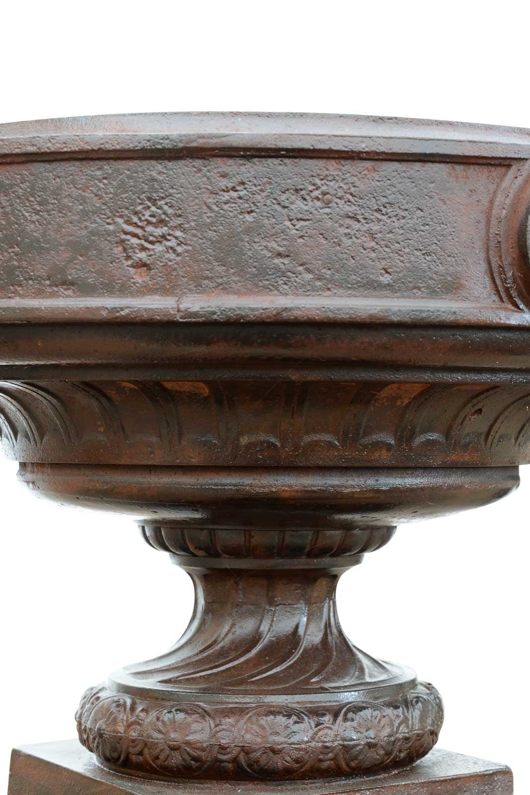 Dating from the late 19th century, pair of cast iron vase with rosettes decorations upper part and gadroons lower part. Base: 8 x 8 in.