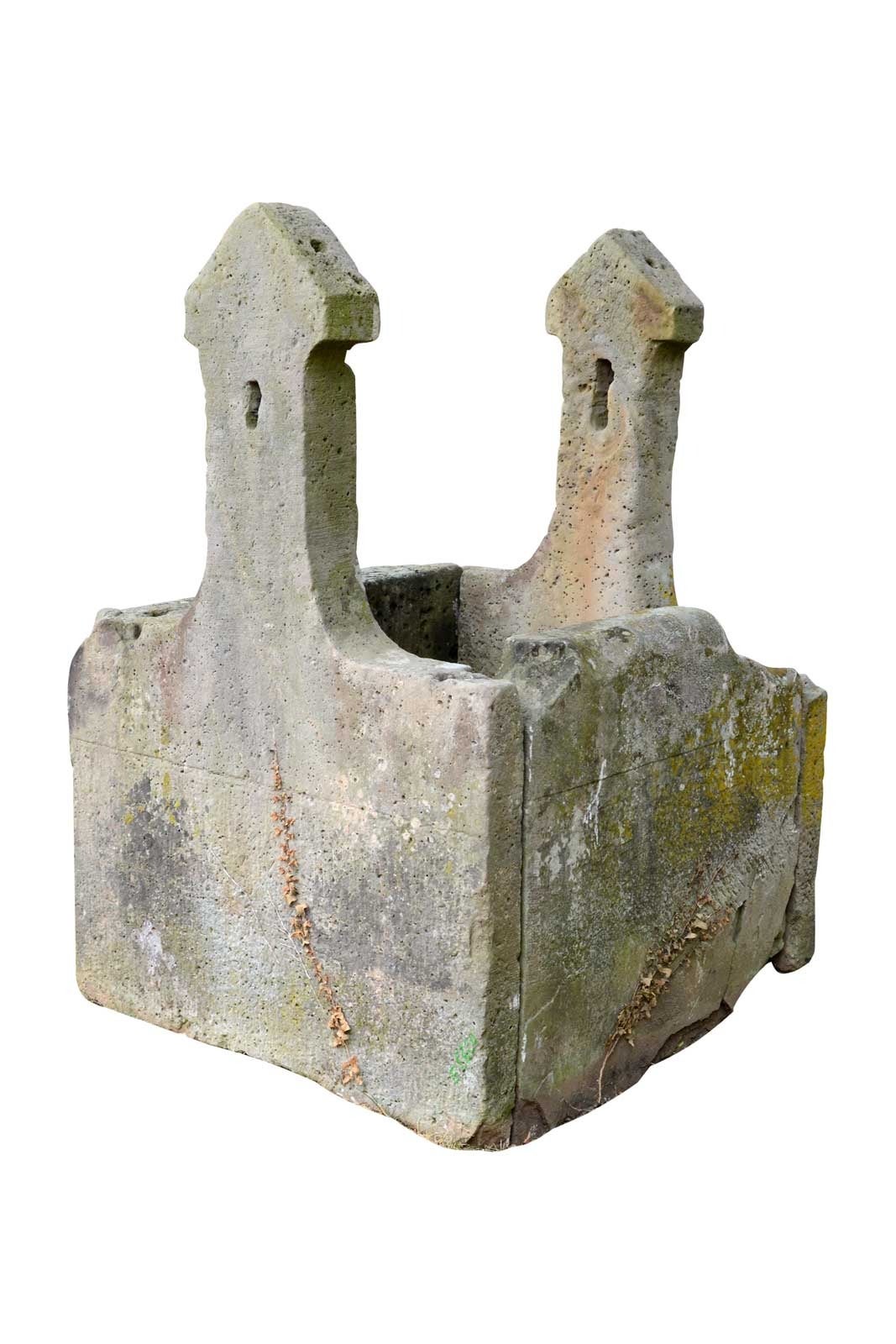 Dating from the 19th century, sandstone well curbstone whose two brackets used to support a wooden winding drum.