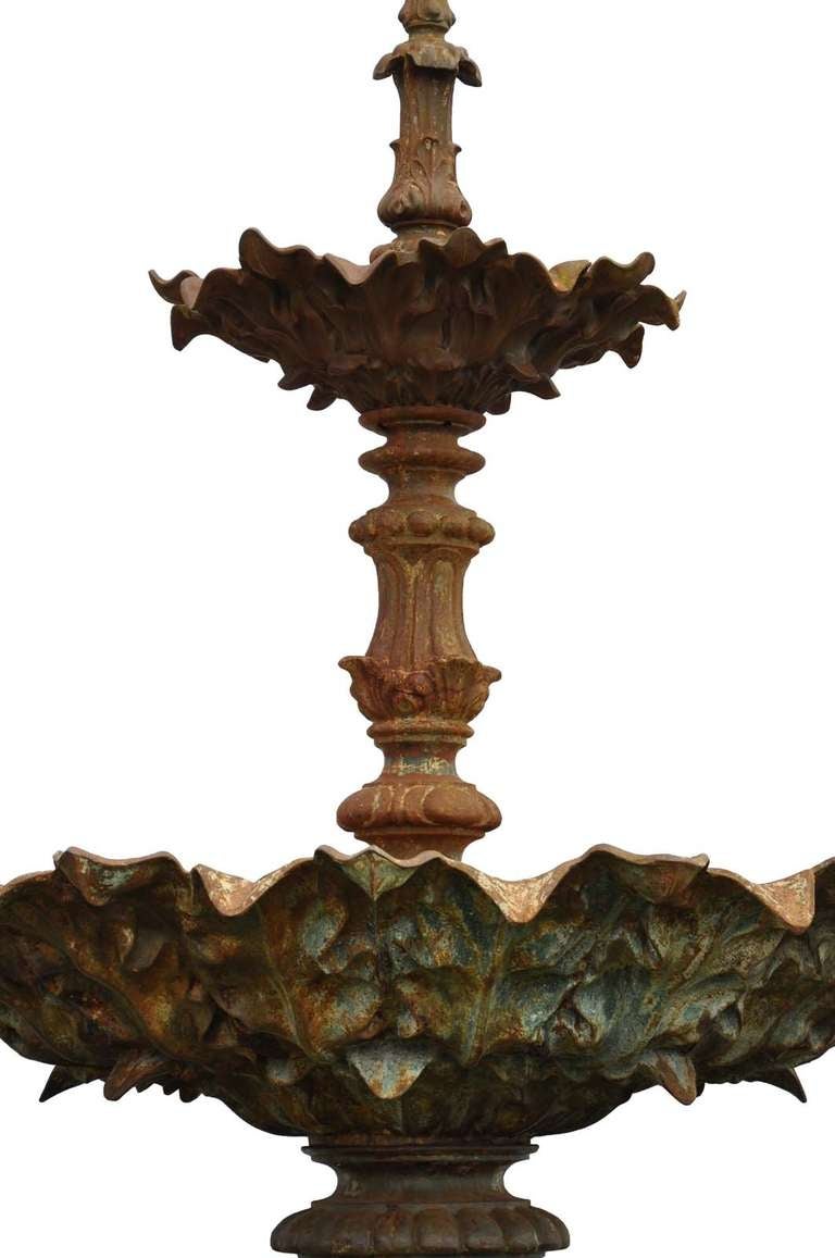 A French cast iron fountain cast by Val d'Osne and dated late 19th century. The two graduated tiers cast to the undersides with foliage ornament, supported on a leaf wrapped, fluted and lobed central baluster column, on a circular stepped base.