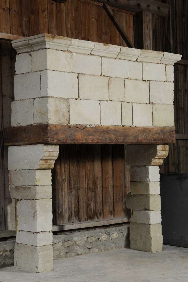 A rustic Louis the 13th country style limestone and wood fireplace dated 17th century. Opening : 67 in. H. x 76 in. W.