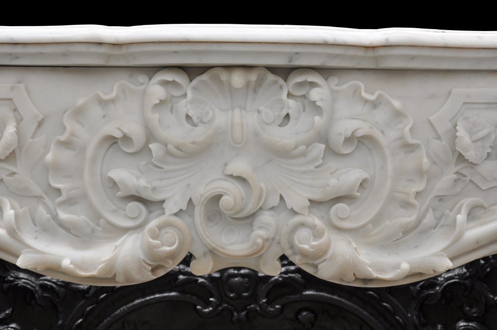A French Louis XV style white marble fireplace dated 19th C. and her cast iron firebacks. Maximum depth with the cast iron firebacks : 27 in. Hearth opening : 34 x 47 in.