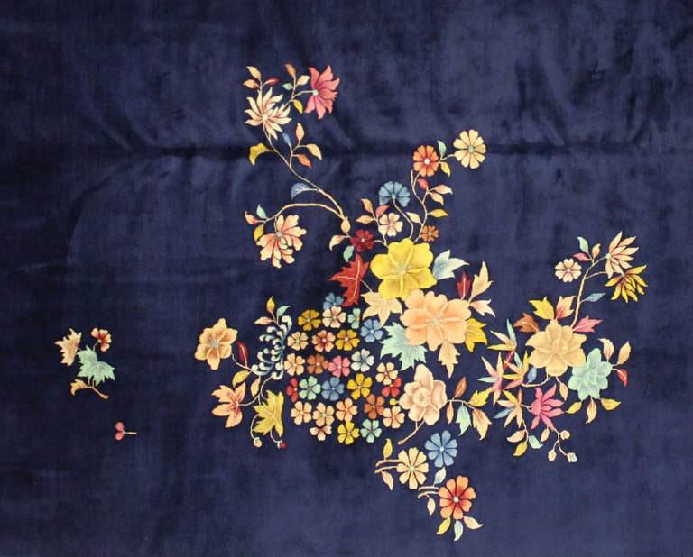 This beautiful modern second quarter 20th century Chinese Art Deco piece has a navy blue background with a multi-colored cluster of flowers.