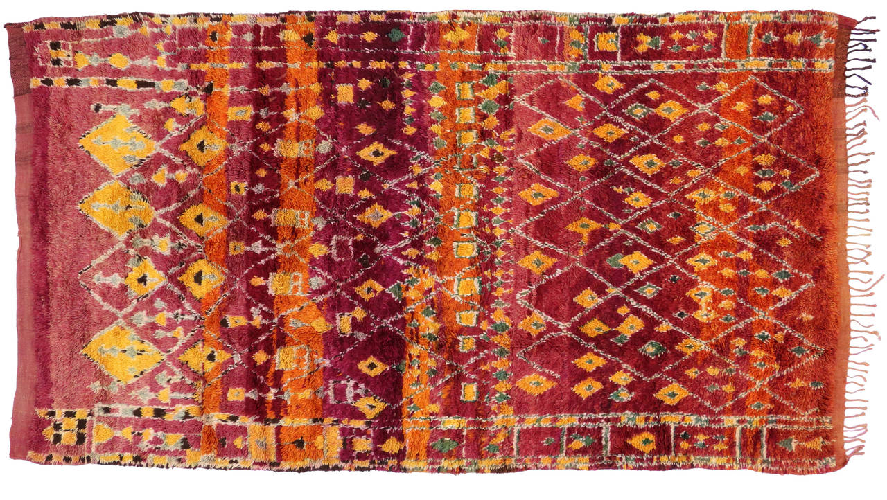 Bursting of Indian summer colors from cayenne red, celosia orange, freesia yellow to deep maroon, plum, cranberry and sage green, this vintage Moroccan rug is truly a magical sight to behold and will leave you spellbound. The color orange brings