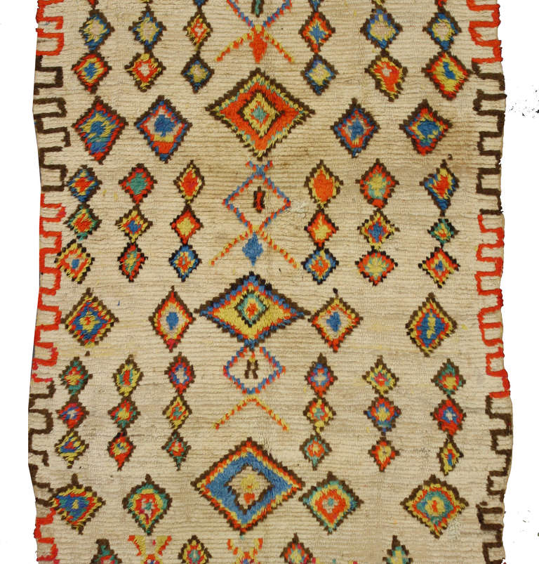 Admired for their strong sense of geometric structure and their colorful rainbow compositions, Moroccan rugs from the Azilal region are highly sought after by interior designers and decorators. This Moroccan rug features an array of vibrant colors