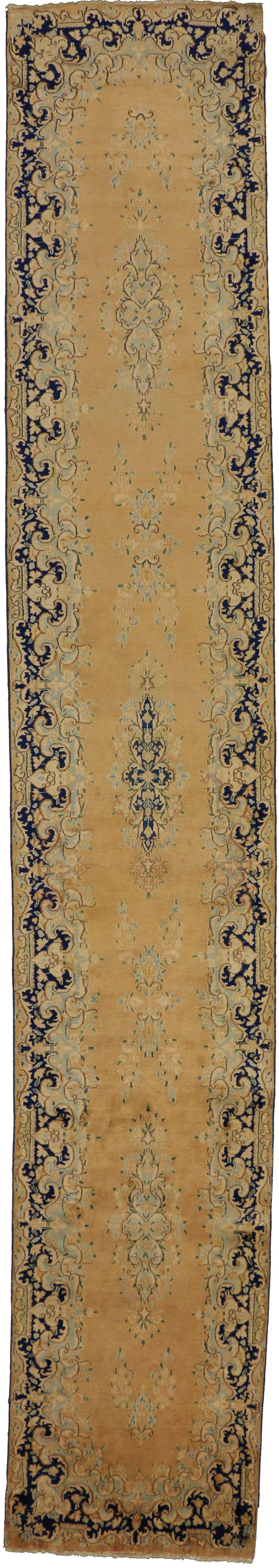 73658-73659 Pair of Matching Vintage Persian Kerman Hallway Runners. 
This vintage Persian Kerman hallway runner, crafted meticulously from hand-knotted wool, boasts captivating features such as an ink blue floral medallion at the center,