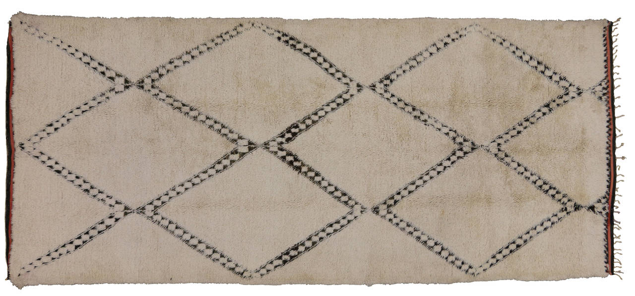 With its well defined lines and natural beauty, this Berber Moroccan rug is believed to protect the human spirit from negative energy and shield the human body from the elements. Beni Ouarain (Beni Ourain) rugs are prized for their exciting,