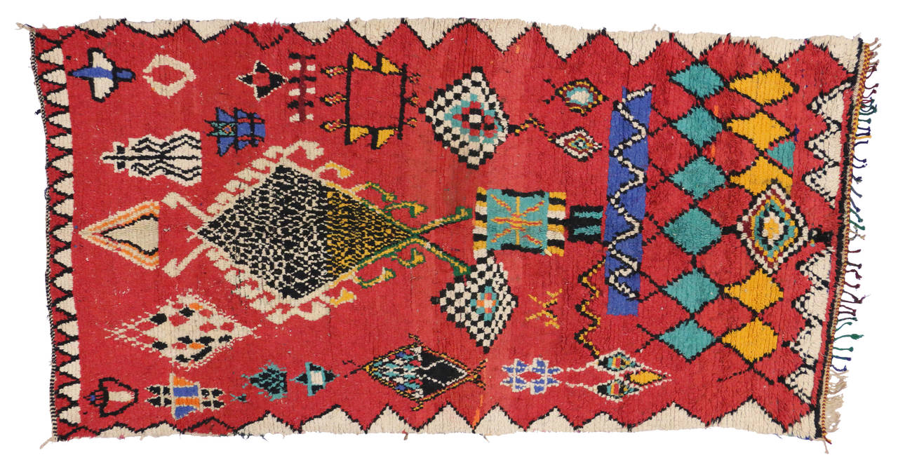 This striking colored rug was made by the tribes of the Azilal province in the high Atlas Mountains of Morocco. In Berber culture, the color red symbolizes strength and protection, blue symbolizes wisdom, yellow represents eternity and green stands
